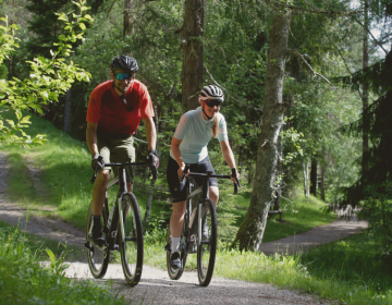 Gravelbiker im Wald auf einem Radweg
