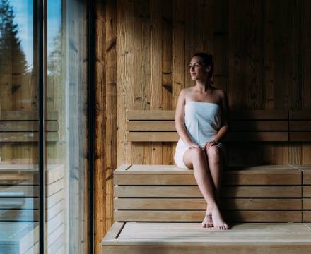 Frau sitzt in der Sauna und blickt nach außen