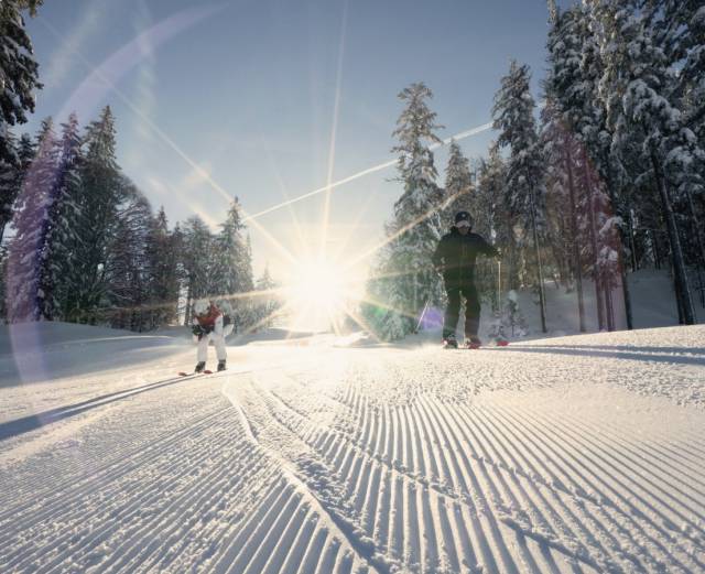 Skifahrer auf einer sonnigen Skipiste in Tirol